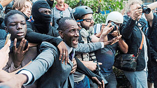 Mit weit ausgebreiteten Armen bildet Bürgermeister Bally Bagayoko einen menschlichen Schutzwall vor den Jugendlichen. Die Aufnahme aus Saint-Denis wurde zum Sinnbild seines Einsatzes bei den Protesten. Mit weit ausgebreiteten Armen bildet Bürgermeister Bally Bagayoko einen menschlichen Schutzwall vor den Jugendlichen. Die Aufnahme aus Saint-Denis wurde zum Sinnbild seines Einsatzes bei den Protesten.