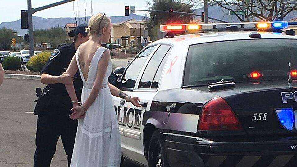Das vom Marana Police Department veröffentlichte Foto zeigt eine 32 Jahre alte Braut in Handschellen, die von Polizisten zum Einsatzfahrzeug geführt wird. Das vom Marana Police Department veröffentlichte Foto zeigt eine 32 Jahre alte Braut in Handschellen, die von Polizisten zum Einsatzfahrzeug geführt wird.