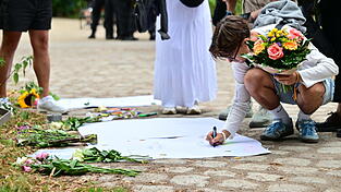 Am Tag nach der Tat legen Passanten Blumen nieder. Am Tag nach der Tat legen Passanten Blumen nieder.