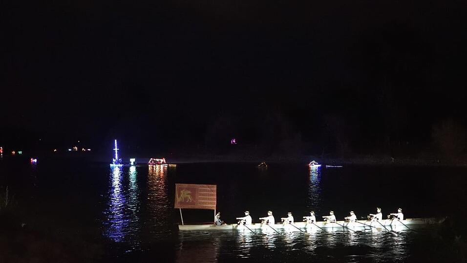 Bunt beleuchtete Boote fahren bei der Lampionfahrt über die Donau.