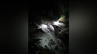 Einsatzkräfte der Bergwacht kehren am Samstagabend in der Nähe der Maiwand bei Flintsbach am Inn von dem Ort zurück, an dem drei Bergwanderer ums Leben gekommen sind.