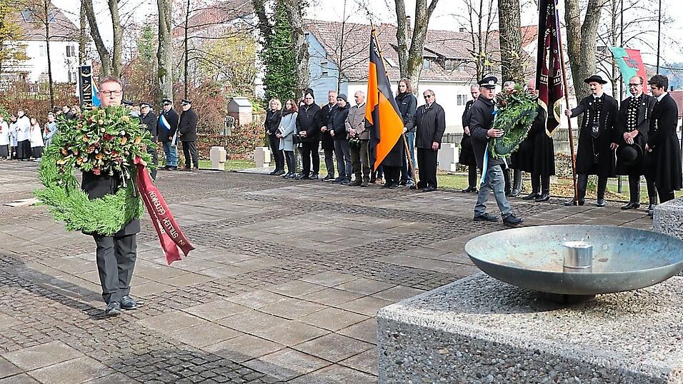 Flankiert von den gesenkten Fahnen der teilnehmenden Vereine, nämlich Feuerwehr, Kriegerverein, Kolpingsfamilie und Hallertauer Volkstrachtenverein, schritten Bürgermeister Helmut Fichtner und Kriegervereinschef Werner Bock unter Böllersalut zur Kranzniederlegung am Ehrenmal.