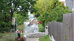 Sandsäcke, Pumpen, Hochwasserschutzwände und ein Boot sind in der Werftstraße am Donnerstag zu sehen.