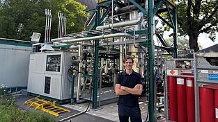 Christian Gro&szlig;hauser vor seiner &bdquo;BioFarm&ldquo; und einem der SER Fault&uuml;rme.