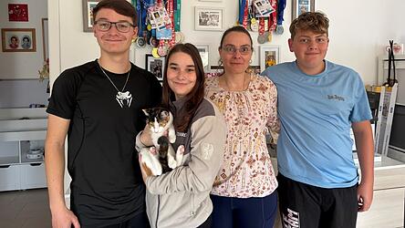 Justin (v.l), Sophie, Kathi und Emil Dziadek stehen vor der Wand, an der Dutzende Medaillen und Fotos h&auml;ngen.