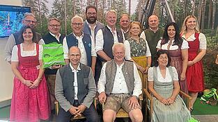 Lob f&uuml;r die Pr&auml;ventionsarbeit der SVLFG gab es von Bundeslandwirtschaftsminister Alois Rainer (sitzend Mitte) und Bezirksb&auml;uerin Claudia Erndl (sitzend rechts). Mit im Bild stehend MdL Josef Zellmeier (3.v.l.), B&uuml;rgermeister Dr. Albert Solleder (4.v.l.), Landrat Tobias Beck (5.v.l.), Bezirksrat Franz Schreyer (6.v.l.), MdL Mia Goller (4.v.r.) und Stadtr&auml;tin Feride Niedermeier (2.v.r.) sowie Vertreter der SVLFG.