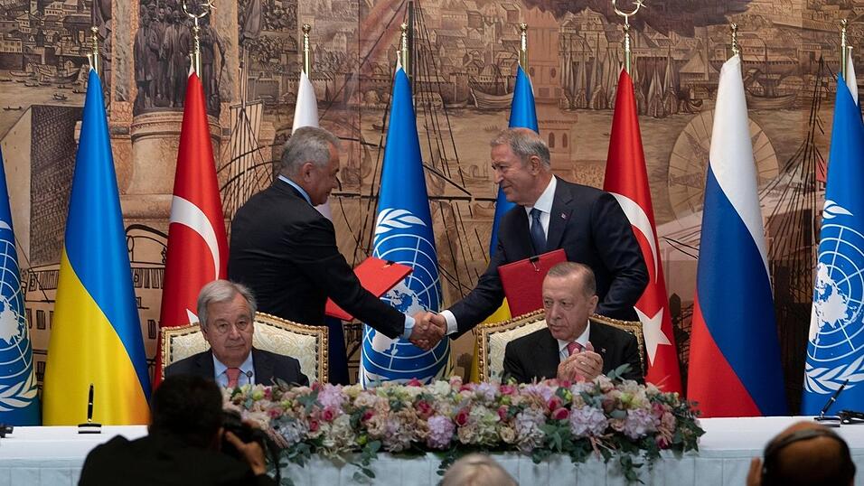 Antonio Guterres (vorne l.) und Recep Tayyip Erdogan (r.) - zwei Vertreter der Delegationen der Ukraine und Russlands reichen sich die Hände.