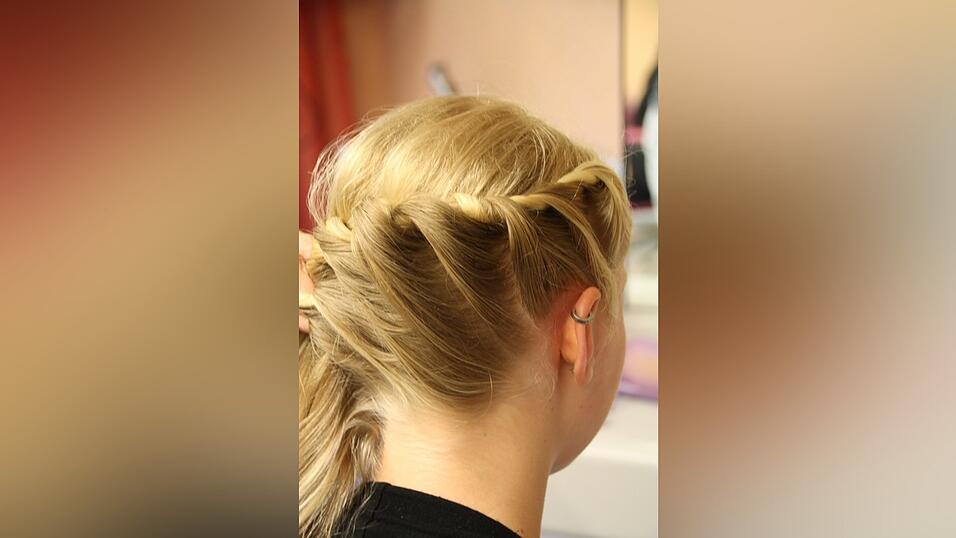 2. Auf der Seite mit weniger Haaren verkordelt sie ihre Haare: Daf&uuml;r nimmt sie zwei Str&auml;hnen, legt die untere &uuml;ber die obere und nimmt immer wieder Haare dazu.