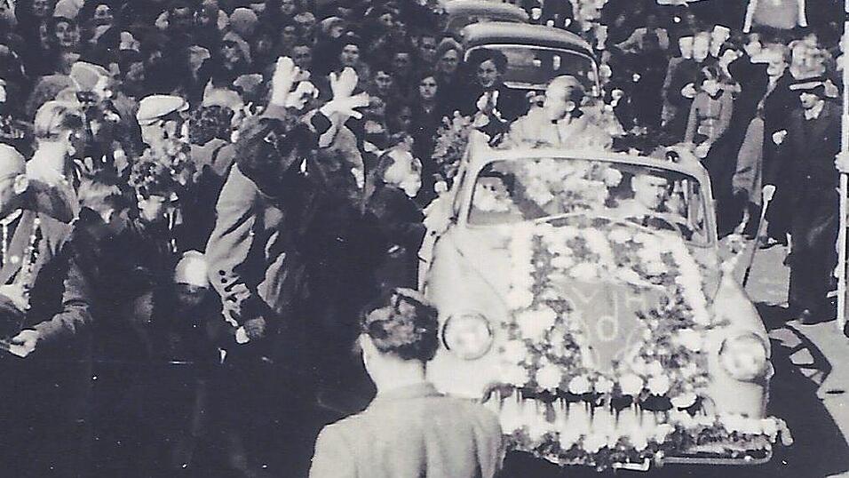 Aus einem Cabrio winkt Josef Pfeil der Menge zu.
