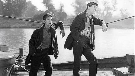 Buster Keaton mit seinem bekannt stoischen Gesichtsausdruck, diesmal auf Flussfahrt.