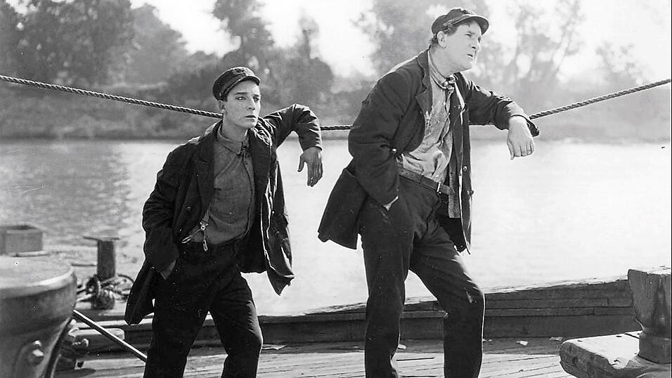 Buster Keaton mit seinem bekannt stoischen Gesichtsausdruck, diesmal auf Flussfahrt. Buster Keaton mit seinem bekannt stoischen Gesichtsausdruck, diesmal auf Flussfahrt.
