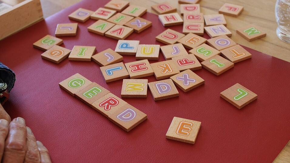 Aus dem Buchstabensalat soll sich Josef Schindler Buchstaben suchen und einen Namen bilden. Danach spielen er und Betreuerin Marina noch Stadt, Land, Fluss.