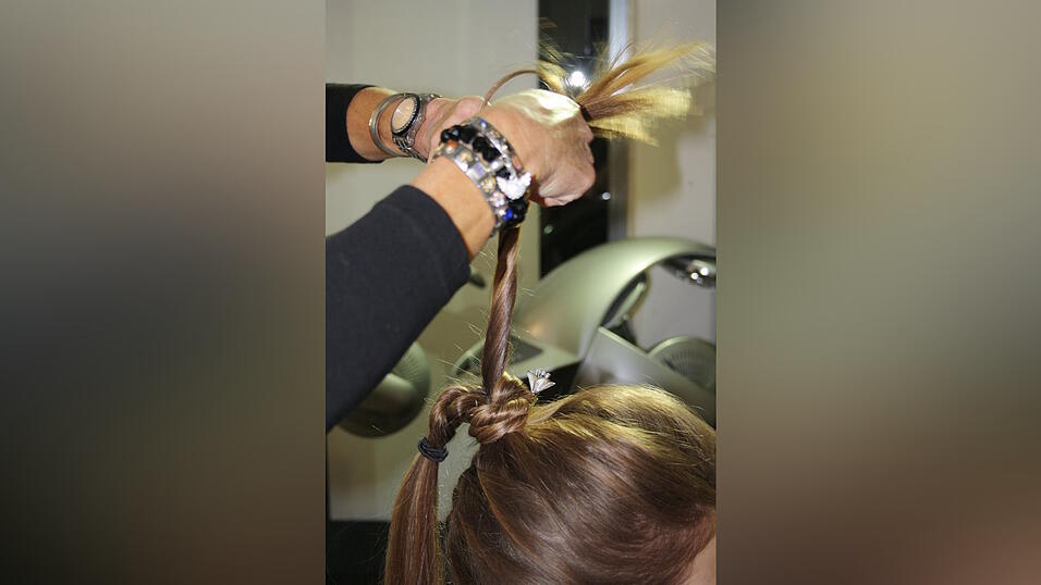 Dafür die offenen Haarsträhnen zwirbeln und um den Haargummi legen. Dafür die offenen Haarsträhnen zwirbeln und um den Haargummi legen.