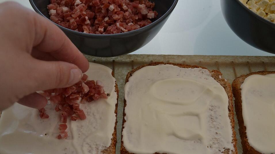 Nun die Schinkenwürfel auf fünf Toasts verteilen.