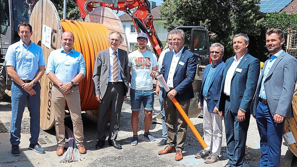 B&uuml;rgermeister Hans Schmalhofer (4.v.r) h&auml;lt hier unz&auml;hlige Glasfaserkabel in seinen H&auml;nden. Eines der bunten R&ouml;hrchen beispielsweise kann 96 Wohneinheiten mit Internet in Lichtgeschwindigkeit versorgen.