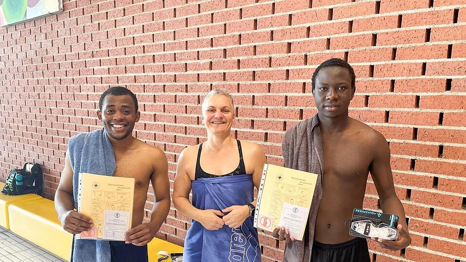 Vereinssport erleichtert das Ankommen: Schwimmlehrerin Alexandra Goldbrunner mit John Cherfils (links) und George Onyango.