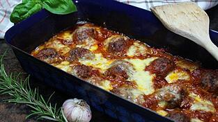 So sehen die leckeren überbackenen Hackbällchen in einer feinen Rotwein-Tomatensauce aus.