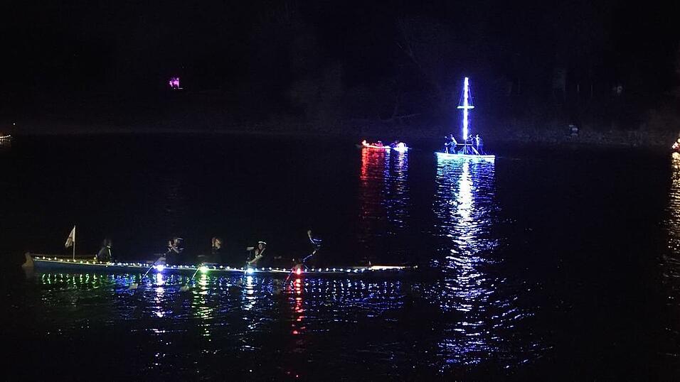 Bunt beleuchtete Boote fahren bei der Lampionfahrt über die Donau.