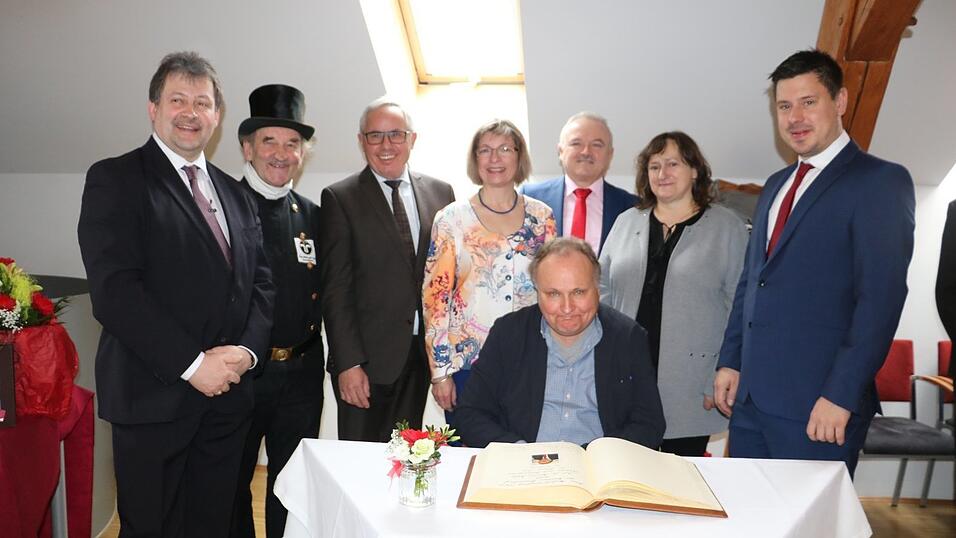 Professor Dr. Martin Balle trug sich nach seiner Festrede in das Goldene Buch der Gemeinde ein. Mit dabei (von links) B&uuml;rgermeister J&uuml;rgen Sommer, ein Gl&uuml;cksbringer, Regensburgs B&uuml;rgermeister J&uuml;rgen Huber, 3. B&uuml;rgermeisterin Brigitte West, stellvertretender Landrat Hans Dechant, Bundestagsabgeordnete Marianne Schieder und 2. B&uuml;rgermeister Wolfgang Weigert.