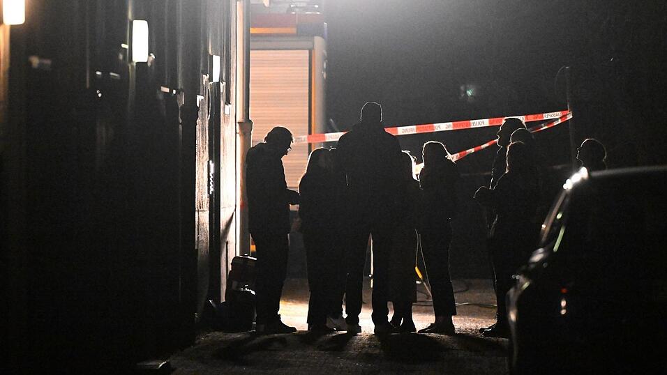 Polizeibeamte, Kriminalpolizei, Spurensicherung und Staatsanwaltschaft stehen vor einem Haus, in dem eine Frau tot aufgefunden worden war.