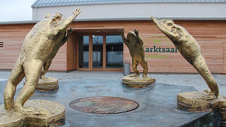 Der Frosch ist das Wappentier des Marktes Pilsting. Der Brunnen von Joseph Michael Neustifter ziert den Vorplatz des Pilstinger Marktsaals, der Ende 2024 nach 23 Monaten Bauzeit er&ouml;ffnet wurde und im Verlauf des Jahres 2025 zum Publikumsmagneten avancierte.