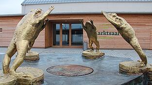 Der Frosch ist das Wappentier des Marktes Pilsting. Der Brunnen von Joseph Michael Neustifter ziert den Vorplatz des Pilstinger Marktsaals, der Ende 2024 nach 23 Monaten Bauzeit er&ouml;ffnet wurde und im Verlauf des Jahres 2025 zum Publikumsmagneten avancierte.