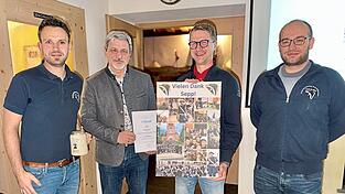 Josef Beer zusammen mit B&uuml;rgermeister Sandro Bauer sowie den beiden Spielmannszug-Vorsitenden Sp&auml;th (ganz links) und Nicolas Traurig (ganz rechts). Beer gab nach 27 Jahren den Tambourstab ab und wurde f&uuml;r sein Engagement mit einer Fotocollage geehrt.