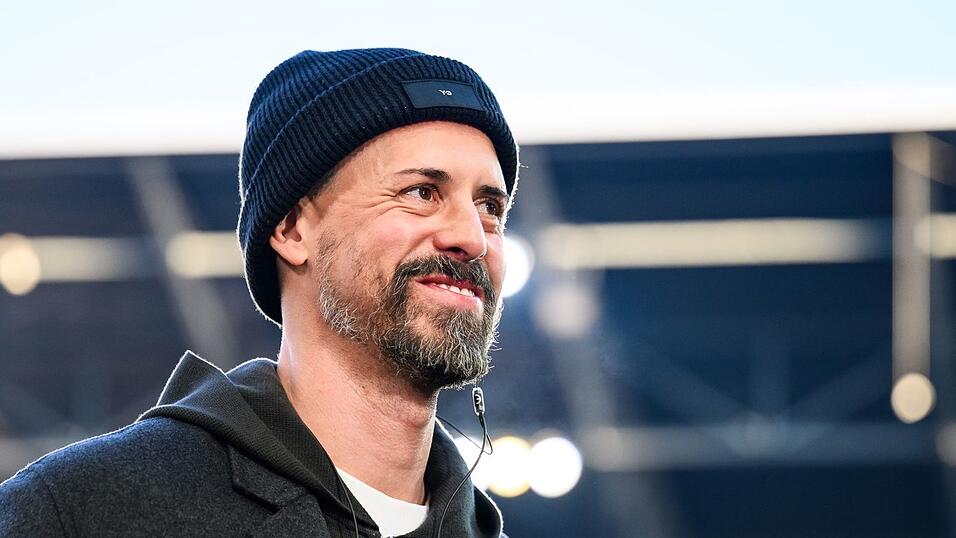 Augsburg-Trainer Sandro Wagner lächelt im Stadion. (Archivfoto)