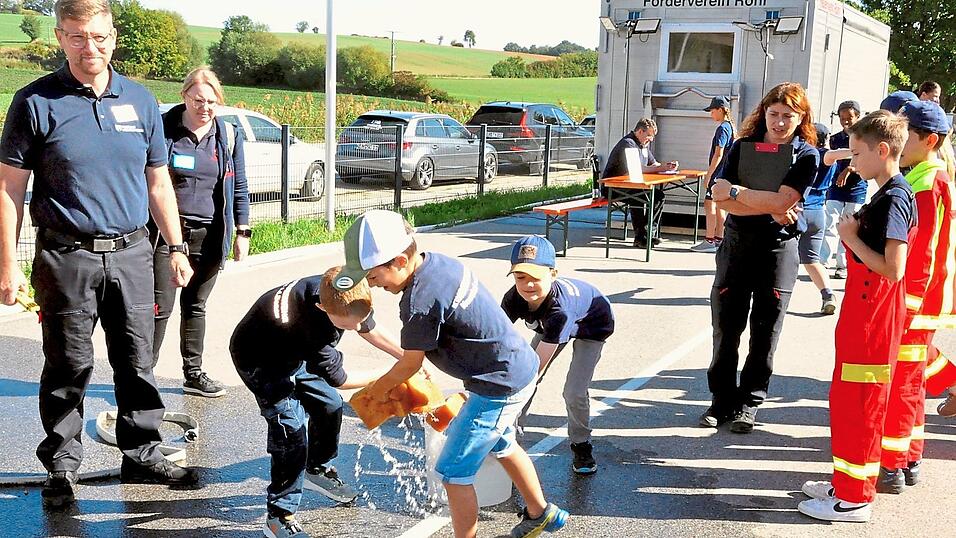 Die Kinder beim Wassertransport mit Schw&auml;mmen.