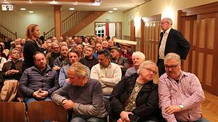 Schlagabtausch beim Bürgerdialog in der Viechtacher Stadthalle. Einige Bürger werfen den Behörden vor, sie bewusst im Dunkeln gelassen zu haben. Ein Zuhörer will seinen Ärger mit einem Brett vor dem Kopf zum Ausdruck bringen.