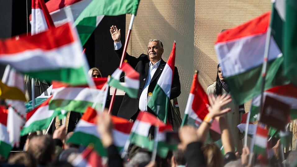 Der ungarische Premierminister Viktor Orban erhebt das Wort vor einem Meer ungarischer Flaggen.