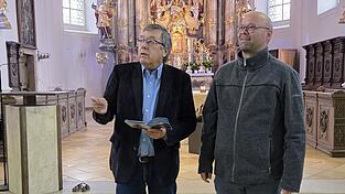Pfarrer Thomas Winderl (r.) und Kirchenpfleger Friedrich Costa begutachten den neuen Kirchenführer.