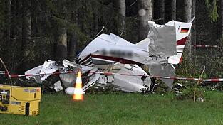 Die Unfallstelle, an der das abgestürzte Flugzeug an einem Waldrand liegt, ist abgesperrt. Die Unfallstelle, an der das abgestürzte Flugzeug an einem Waldrand liegt, ist abgesperrt.