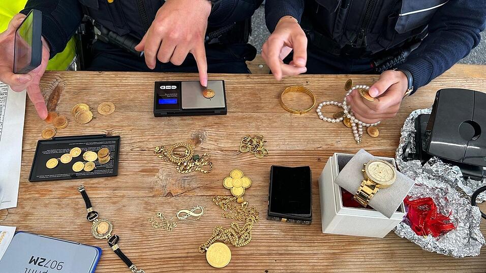 Die Zollbeamten wiegen den sichergestellten Goldschmuck.