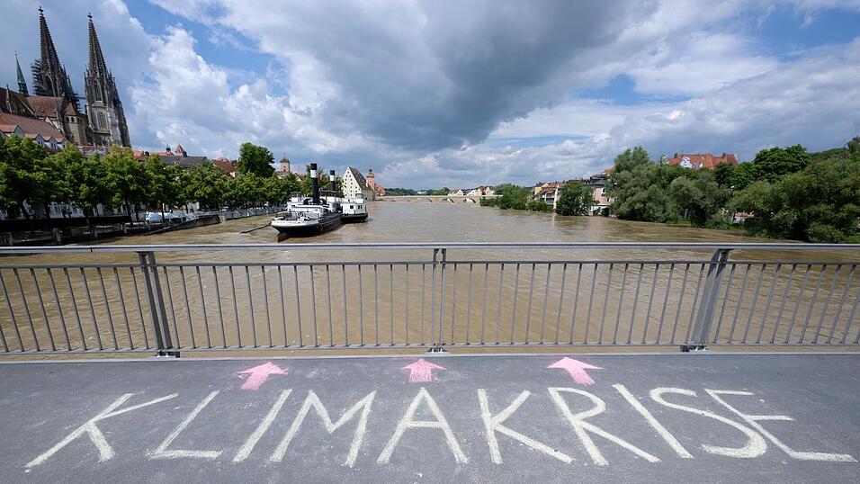 Das Wort „Klimakrise“ ist auf der Eisernen Brücke in Regensburg zu lesen. Überschwemmungen sind nicht die einzige Folge der Erderwärmung. (Archiv) Das Wort „Klimakrise“ ist auf der Eisernen Brücke in Regensburg zu lesen. Überschwemmungen sind nicht die einzige Folge der Erderwärmung. (Archiv)