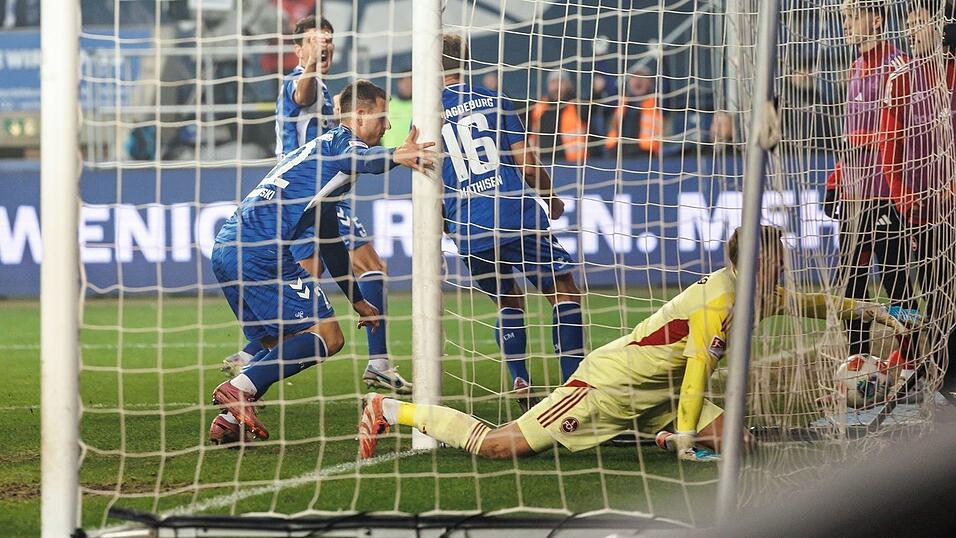 Der Anfang vom Ende: Nürnbergs Torwart Jan Reichert landet beim 0:1 mit dem Ball im Netz. Links Magdeburgs Torschütze Mateusz Zukowski.
