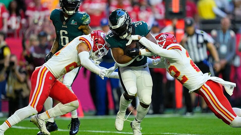 Philadelphia Eagles Running Back Boston Scott (35) wird von Kansas City Chiefs Cornerback Trent McDuffie (21) und Safety Juan Thornhill (22) angegriffen. Philadelphia Eagles Running Back Boston Scott (35) wird von Kansas City Chiefs Cornerback Trent McDuffie (21) und Safety Juan Thornhill (22) angegriffen.