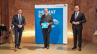 Finanz- und Heimatminister Albert F&uuml;racker (r.) &uuml;berreichte B&uuml;rgermeister Albin Dietrich (Mitte) das 'G&uuml;tesiegel Heimatdorf 2021'. Gl&uuml;ckw&uuml;nsche gab's von Regierungspr&auml;sident Rainer Haselbeck.