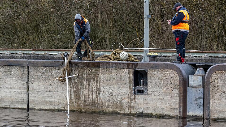 Arbeiter holen am Freitagnachmittag Treibgut aus der Schleuse Geisling, in der zuvor das 85 Meter lange Güterschiff Achim untergegangen ist. Wie konnte es dazu kommen? Arbeiter holen am Freitagnachmittag Treibgut aus der Schleuse Geisling, in der zuvor das 85 Meter lange Güterschiff Achim untergegangen ist. Wie konnte es dazu kommen?