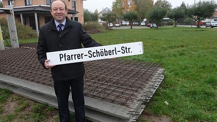 Bürgermeister Christian Hirtreiter mit dem Straßenschild.