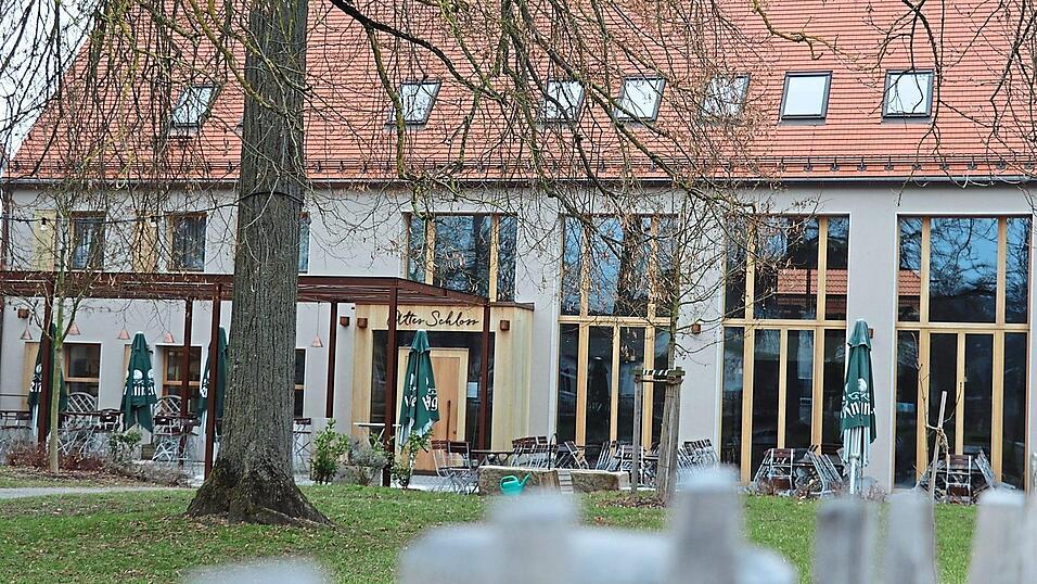 Hinter einem Biergarten liegt der Eingang vom Alten Schloss in Niedertraubling.