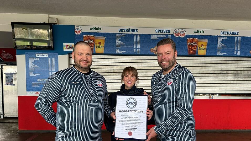 Das Catering-Team des Ostseestadions Rostock um Gesch&auml;ftsf&uuml;hrer Christoph Wulff (r) und K&uuml;chenchef Jens Schaumburg (l) hat das l&auml;ngste Fischbr&ouml;tchen der Welt produziert. Best&auml;tigt wurde der Rekord von Laura Koblischek (M) vom Rekord-Institut Deutschland. (Foto Handout)
