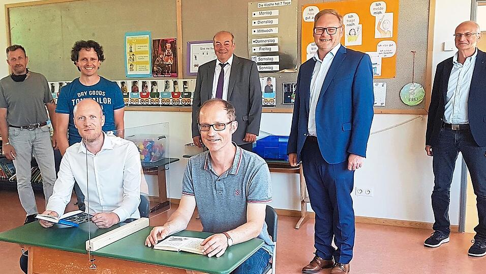Die Bürgermeister Michael Schwarzfischer (links, sitzend) und Eduard Hochmuth (rechts, sitzend) testeten die im Eigenbau hergestellte Sicherheitsabtrennung für Schultische. Die Idee dazu entstand im Kollegium der Schule Walderbach und wurde von Hausmeister Andreas Zellner (links) ausgeführt. Auch Schulamtsdirektor Rudolf Hofmann (Mitte) begutachtete das Modell und dankte dem Team um Rektor Alexander Seidl (Zweiter von rechts), Konrektor Alfred Lang (rechts) und Sicherheitsbeauftragtem Uwe Heyne (Zweiter von links) für das vorausschauende Engagement zur Sicherheit der Schüler. Die Bürgermeister Michael Schwarzfischer (links, sitzend) und Eduard Hochmuth (rechts, sitzend) testeten die im Eigenbau hergestellte Sicherheitsabtrennung für Schultische. Die Idee dazu entstand im Kollegium der Schule Walderbach und wurde von Hausmeister Andreas Zellner (links) ausgeführt. Auch Schulamtsdirektor Rudolf Hofmann (Mitte) begutachtete das Modell und dankte dem Team um Rektor Alexander Seidl (Zweiter von rechts), Konrektor Alfred Lang (rechts) und Sicherheitsbeauftragtem Uwe Heyne (Zweiter von links) für das vorausschauende Engagement zur Sicherheit der Schüler.