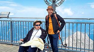 Die Brüder Thomas (links) und Stephan stehen auf der Aussichtsplattform der Zugspitze und genießen die Zeit zusammen.