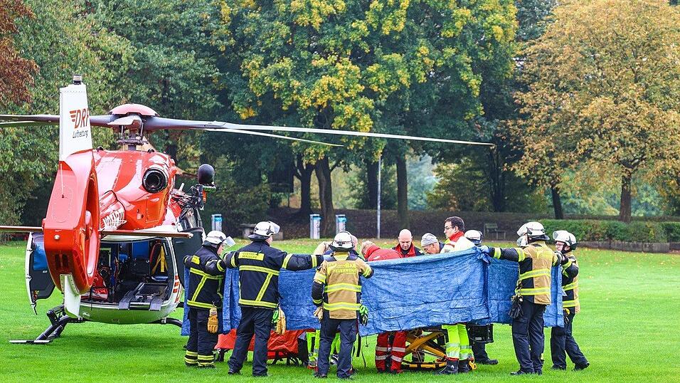 Einsatzkräfte stehen neben einem Rettungshubschrauber.