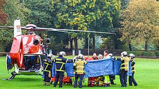 Einsatzkräfte stehen neben einem Rettungshubschrauber.