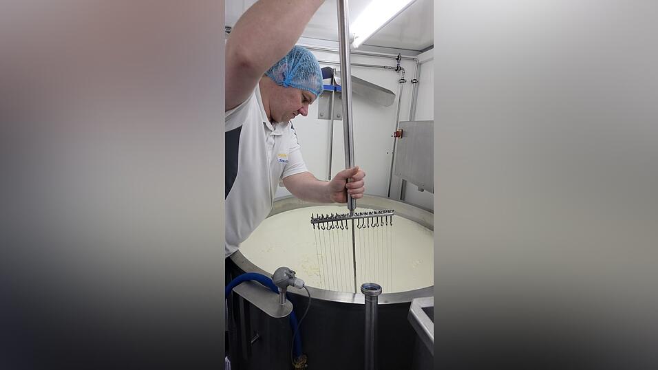 Voller K&ouml;rpereinsatz beim Schneiden der Masse mit der K&auml;seharfe