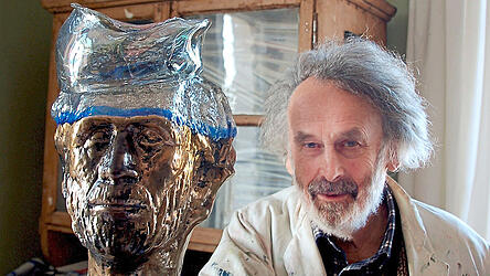 Charakterkopf Erwin Eisch neben einem seiner Glascharakterk&ouml;pfe