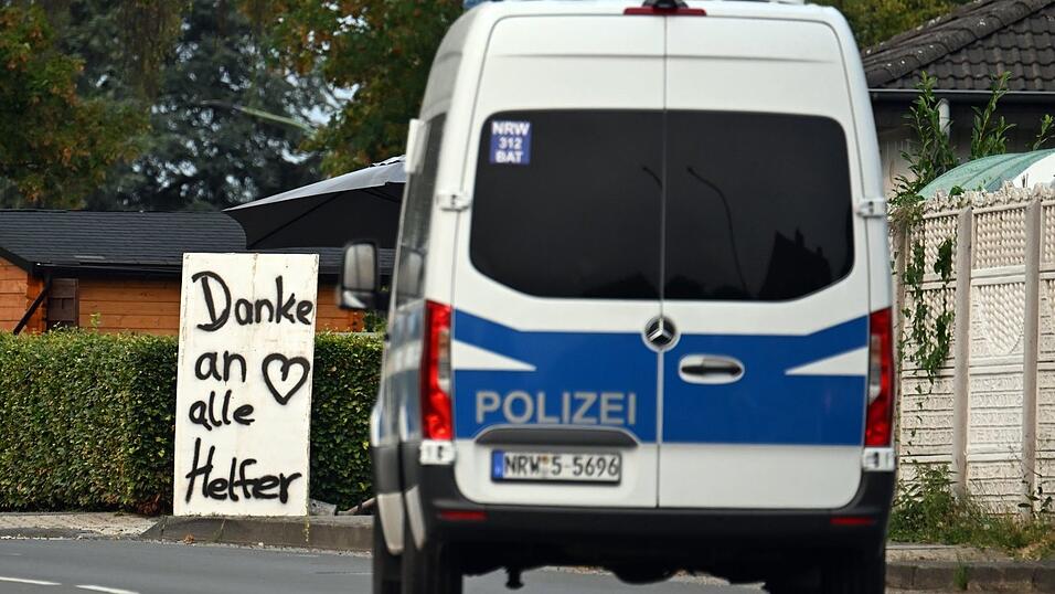 Ein Polizeifahrzeug fährt an einem Schild mit der Aufschrift «Danke an alle Helfer» vorbei. Ein Polizeifahrzeug fährt an einem Schild mit der Aufschrift «Danke an alle Helfer» vorbei.