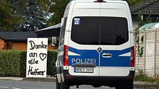 Ein Polizeifahrzeug fährt an einem Schild mit der Aufschrift «Danke an alle Helfer» vorbei. Ein Polizeifahrzeug fährt an einem Schild mit der Aufschrift «Danke an alle Helfer» vorbei.